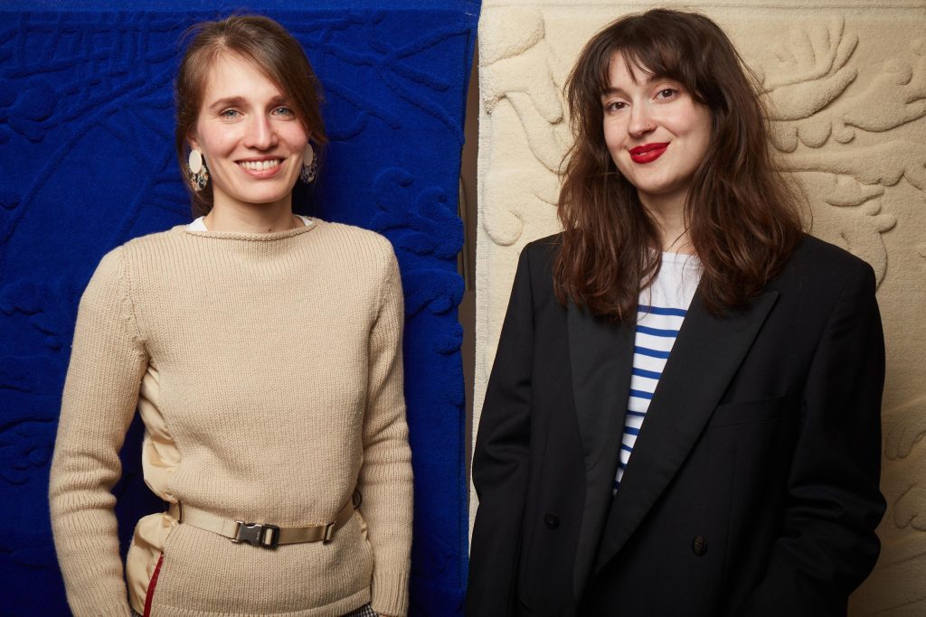 Portrait photo de Charlotte Font & Charlotte Romani, lissières en Savonnerie et co-fondatrices de l'Atelier FONT&ROMANI, devant les pièces de leur première collection Métamorphose IV et Métamorphose V